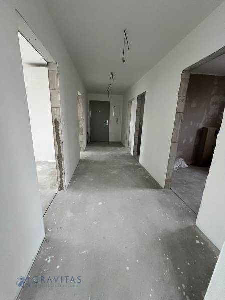A hallway in a 3-room apartment with unfinished plaster and flooring.