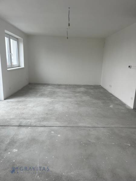Empty room in a 3-room apartment with a concrete floor and a window.