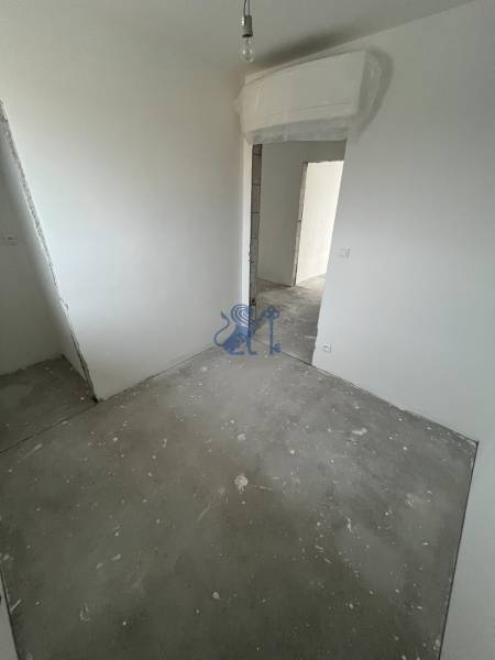 Interior of a 3-room apartment with white walls and unfinished flooring.