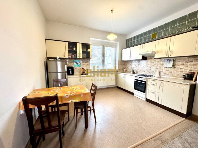 Kitchen in a 2-room apartment with a table, chairs, and a kitchen unit.