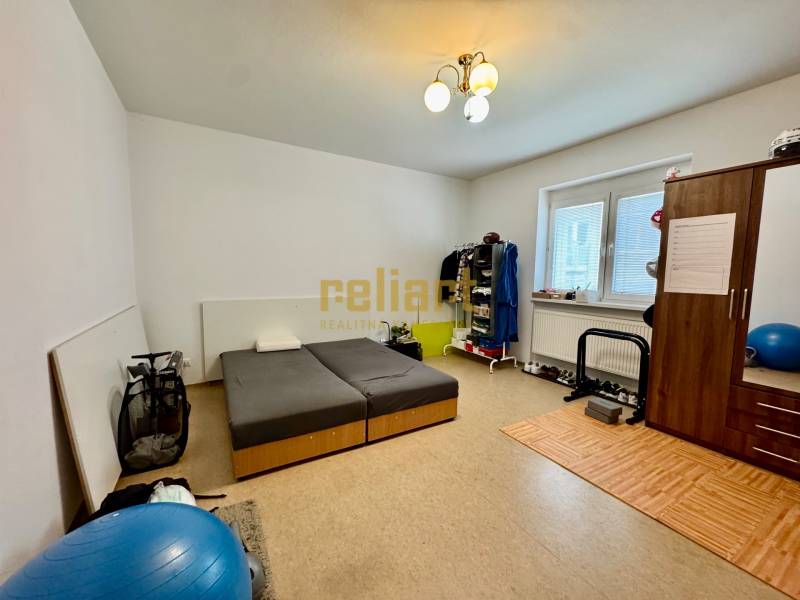 A bedroom with wooden decor, a bed, and a wardrobe in a 2-room apartment with sports equipment.