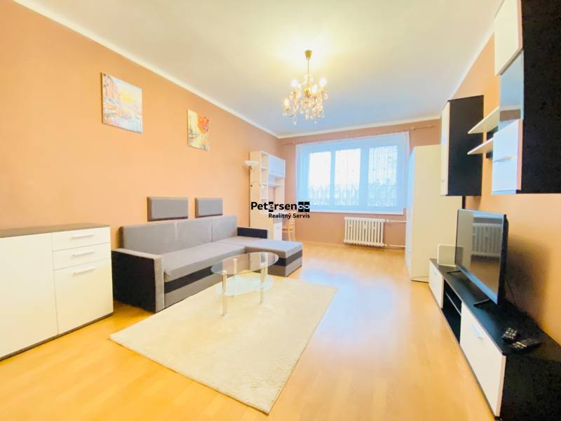 Living room in a two-room apartment with a wooden decor floor, sofa, furniture, chandelier.