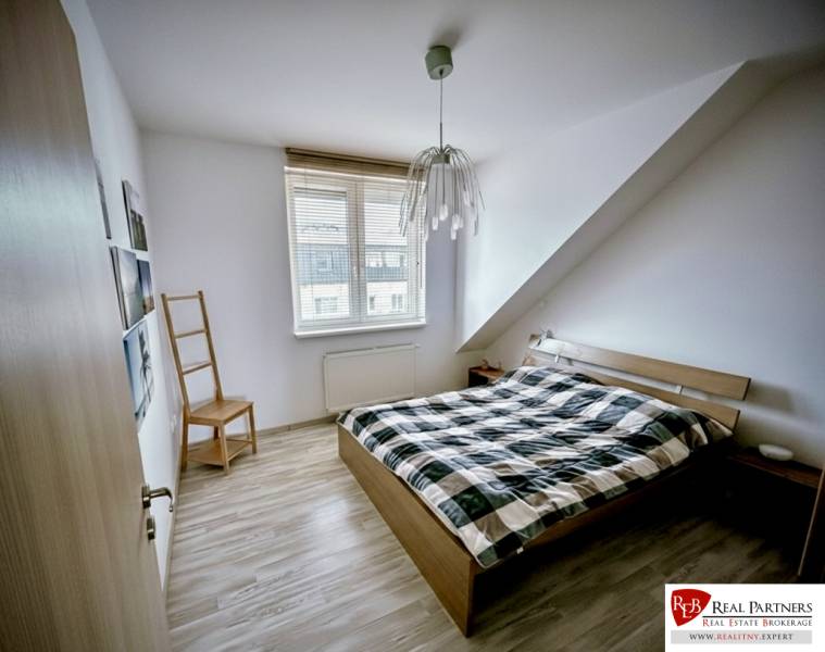 Bedroom in a 3-room apartment with a bed and a wooden decor floor.