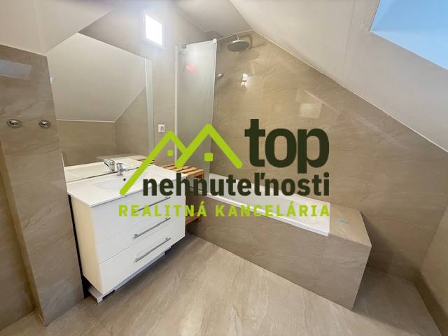 A bathroom in a one-room apartment with a shower and a sink.