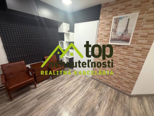 Izba s podlahou s dreveným dekorom a tehlovým obkladom, zariadená sedacím nábytkom.