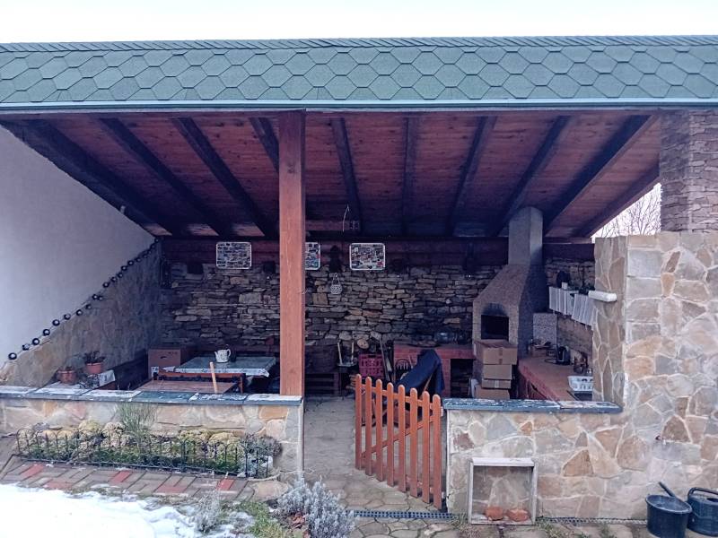 Stone terrace of a family house in Vršatské Podhradie with a fireplace and wooden roofing.
