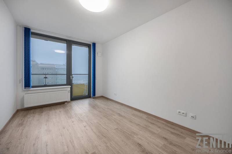 Unfurnished room with a large window and wood-patterned flooring.