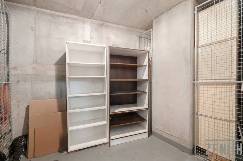 Storage space with two open shelves and cardboard boxes in a 2-room apartment.