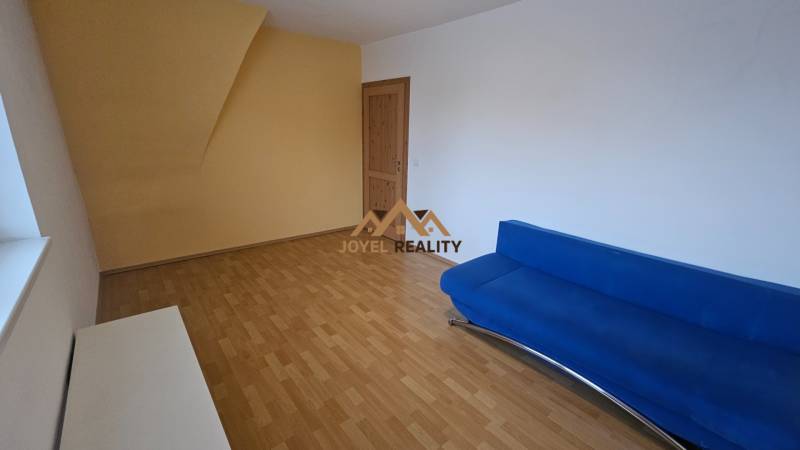 Living room in a 3-room apartment with a wood-patterned floor and a blue couch.
