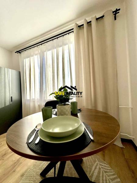 A cozy corner of a studio apartment with a round table and dishes.