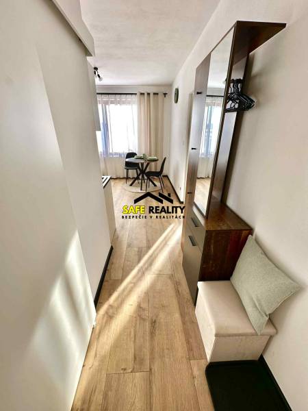 A bright interior with a dining table and wood-decor flooring in a studio apartment.