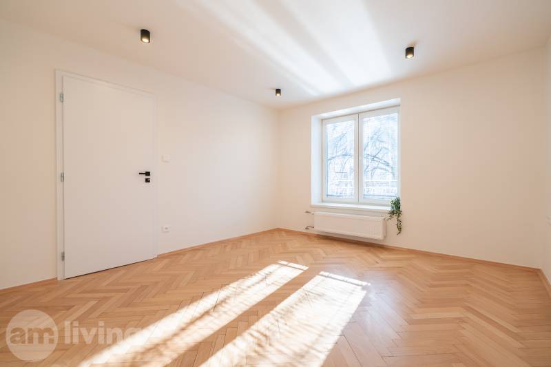A bright room with white walls and a floor with a wood decor in a 3-room apartment.