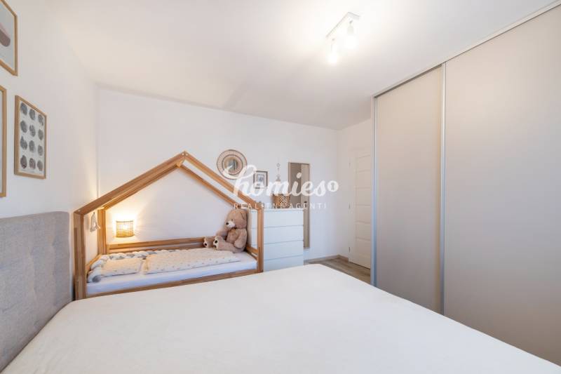 Children's room in a two-room apartment with a children's bed and a wardrobe.