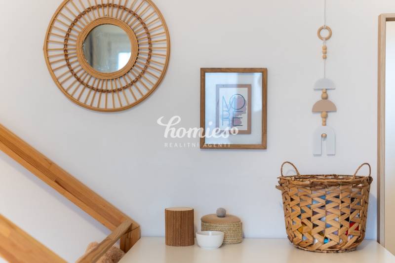 Wooden decorative frame, basket, and mirror on the wall in a 2-room apartment.