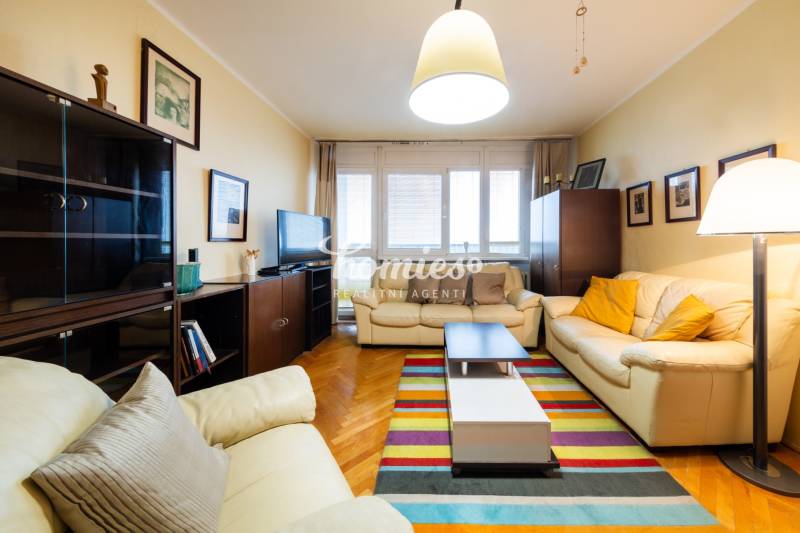 Living room in a 3-room apartment with leather sofas and a wooden decor floor.