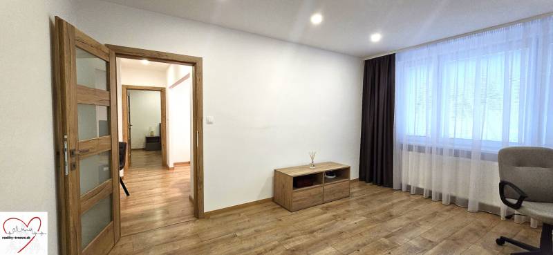 A room in a 3-room apartment with a wooden decor floor, light, and furniture.