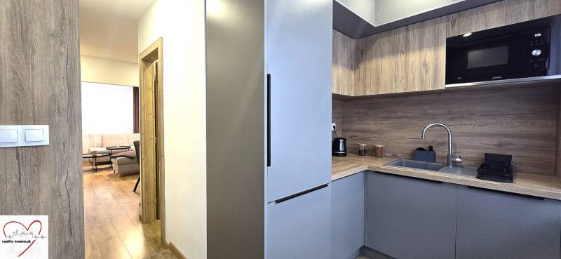 The kitchen of a three-room apartment with a wooden decor floor and modern equipment.