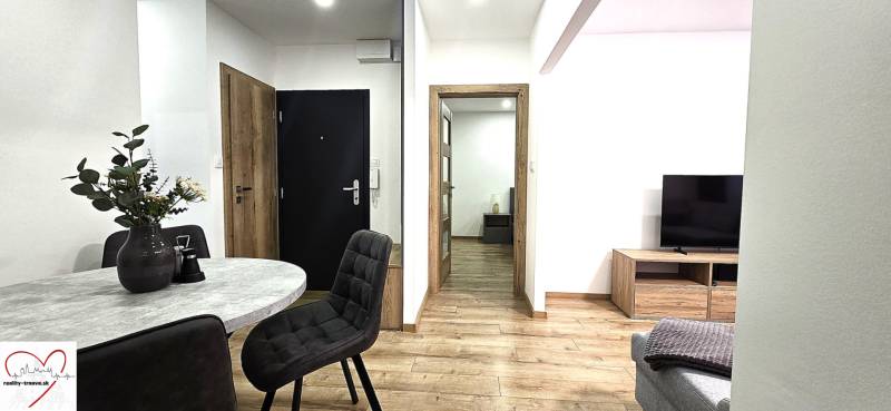 Interior of a 3-room apartment with a wooden decor floor and a stylish table.