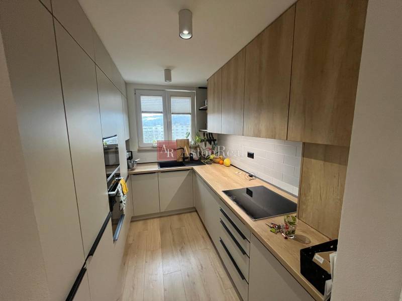 Kitchen in a 4-room apartment with a kitchen unit, appliances, and flooring with a wooden decor.