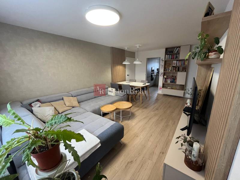 Living room in a 4-room apartment with a corner sofa and a wooden decor floor.