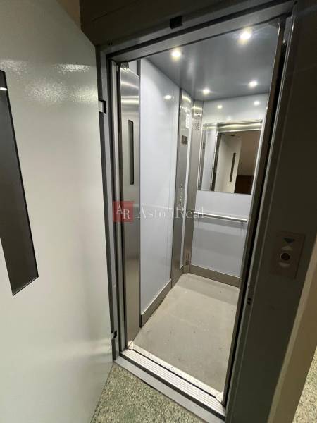 Open elevator with modern interior and metal details in a 4-room apartment.