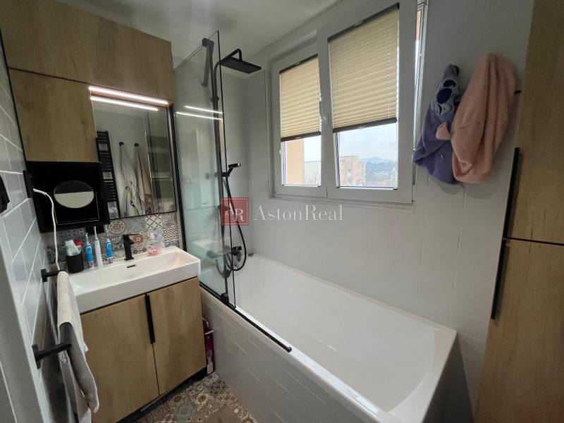 A bathroom with a shower and a bathtub in a 4-room apartment with a wooden decor.