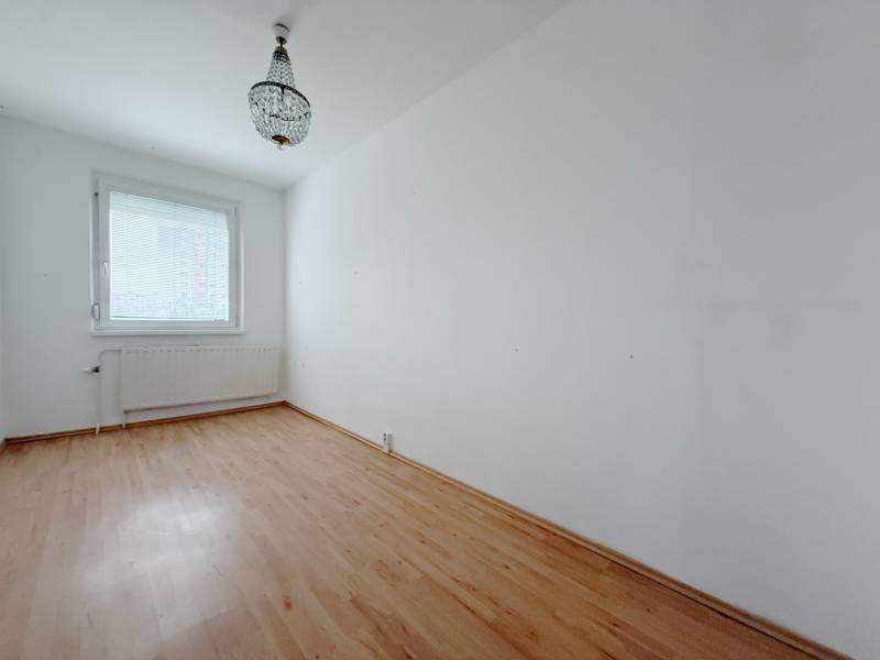 A room in a 4-room apartment with a chandelier and a floor with a wood decor.
