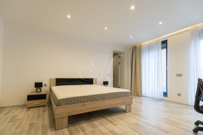 Bedroom in a 2-room apartment with a bed, nightstand, and floor with a wooden decor.