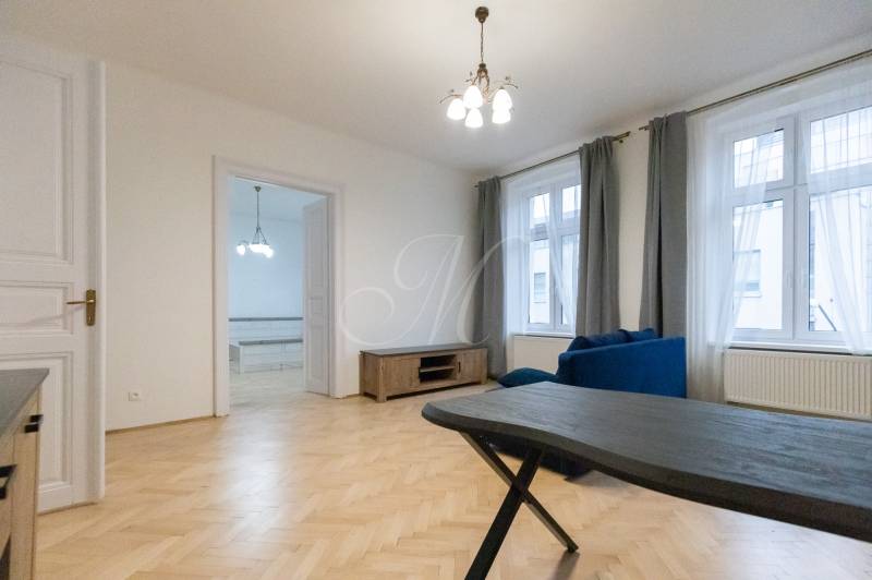 Living room in a 3-room apartment with a wooden decor floor and a blue sofa.