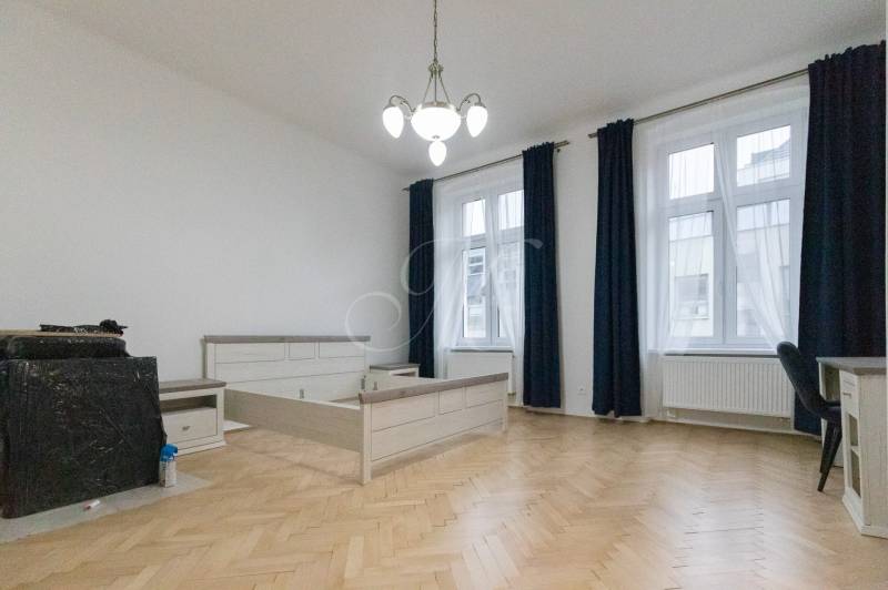 A room with light furniture, a wooden decor floor, and large windows in a 3-room apartment.
