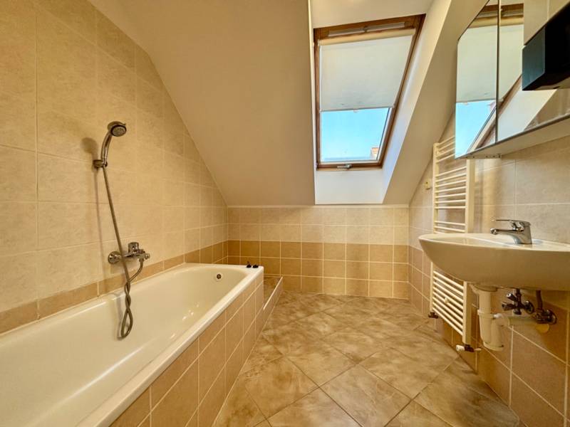 Bathroom in a 2-room apartment with a bathtub and a skylight.