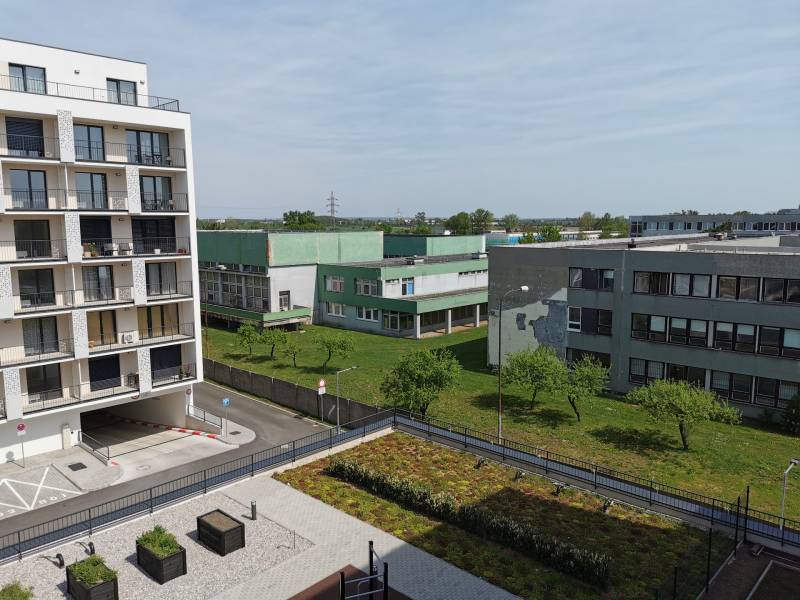 A view of residential buildings and greenery on Eduarda Wenzla in Bratislava-Rača, garages on the right.
