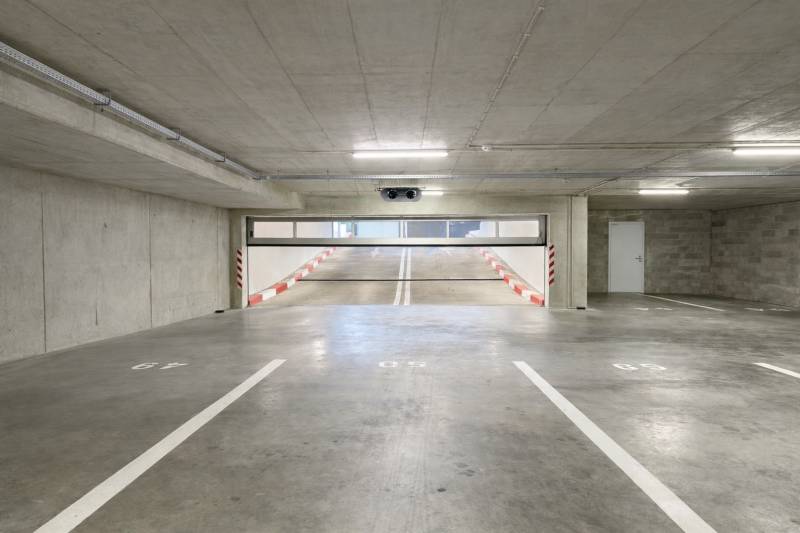 Parking spaces in garages with a ramp and white markings.