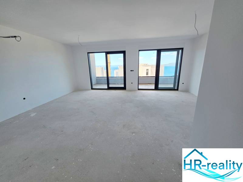 Interior of a holiday apartment with a view through large windows of the sea.