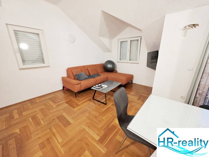Recreational apartment with an orange sofa and a wooden decor floor.