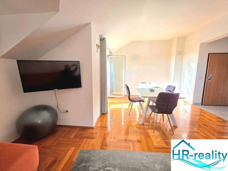 Interior of a holiday apartment with a wooden decor floor and a dining table.