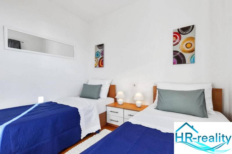 Double room with art on the walls in a 3-room apartment with white walls.