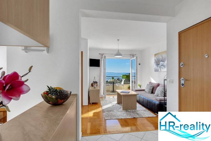Bright living space in a 3-room apartment with a sea view, wooden decor flooring.