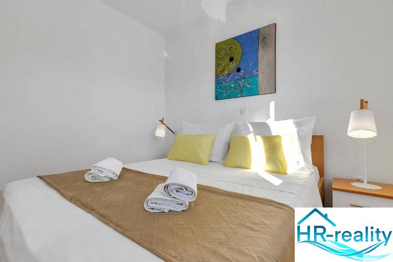 A bedroom in a 3-room apartment with simple furniture, white walls, and yellow decorations.