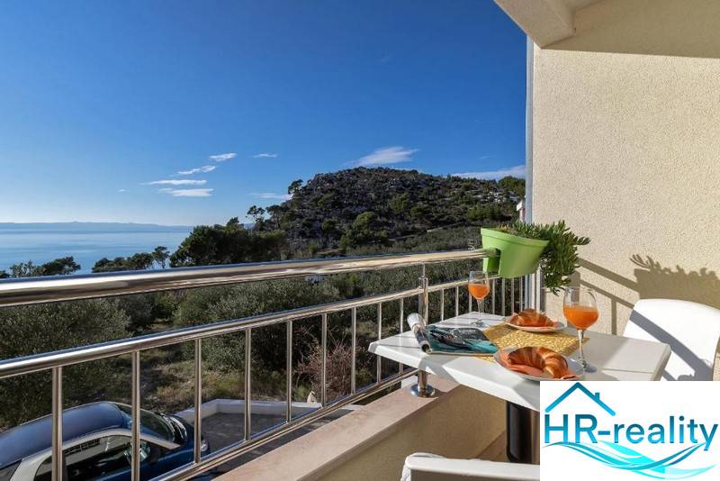 A balcony with a view of the sea, hills, and nature in Makarska, a 3-room apartment.