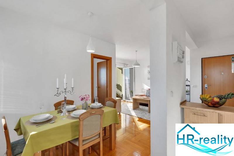 Dining room in a 3-room apartment with a wooden decor floor, set table, candles.