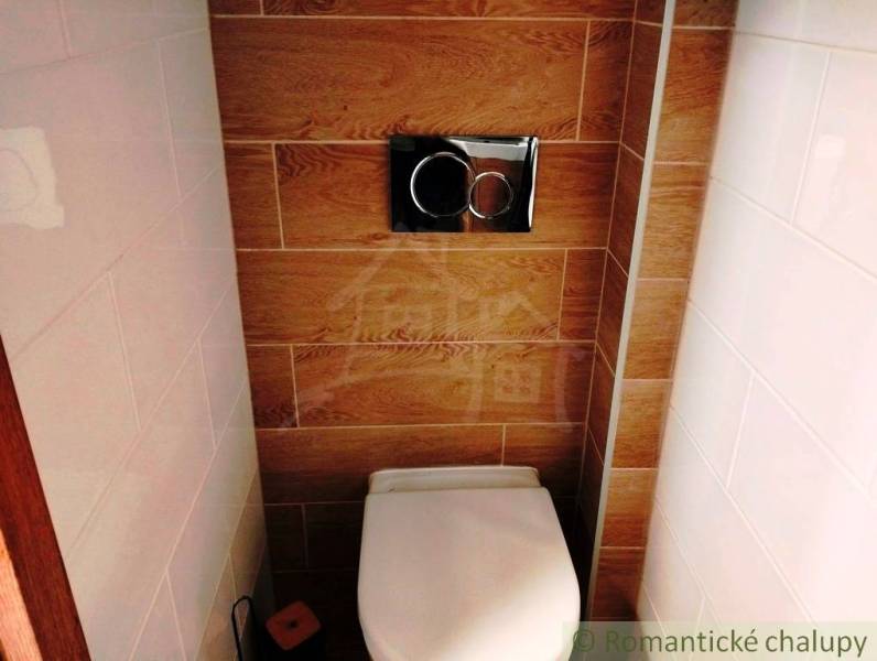 A toilet with wood-effect tiles in a family house.
