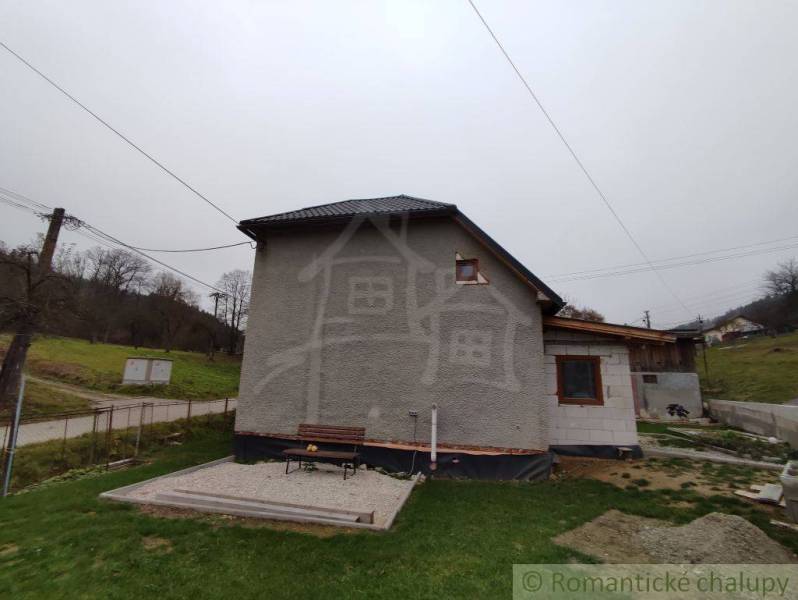 A family house in Jasenica with an extension and a fenced garden on a quiet street.