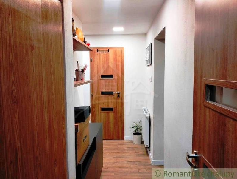 A hallway with wooden doors and a floor with a wooden decor in a family house.