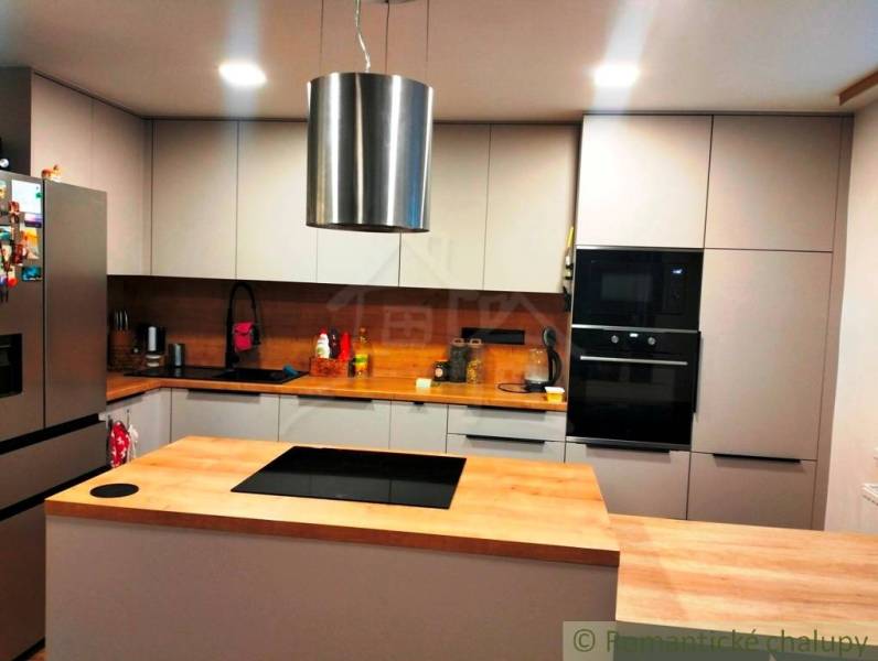 A kitchen in a family house with a wooden decor floor and modern equipment.