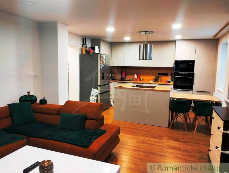 A kitchen with a dining table in a family house, a floor with a wooden decor.