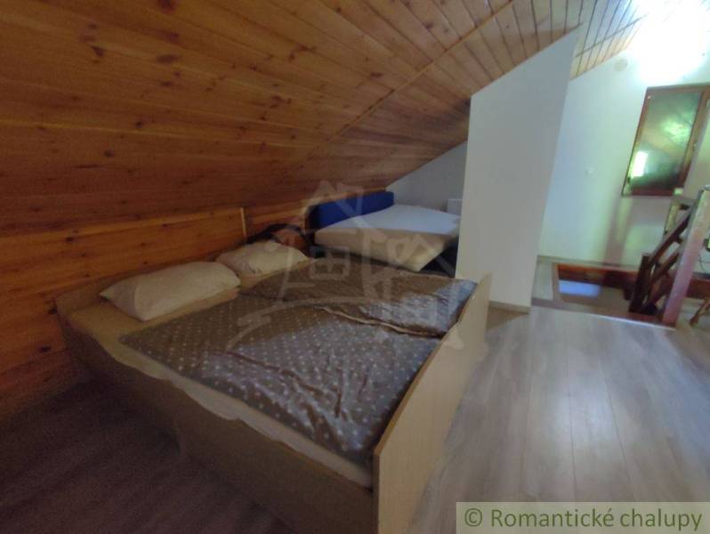 Attic room with wooden paneling and wood-decor flooring in a family house.