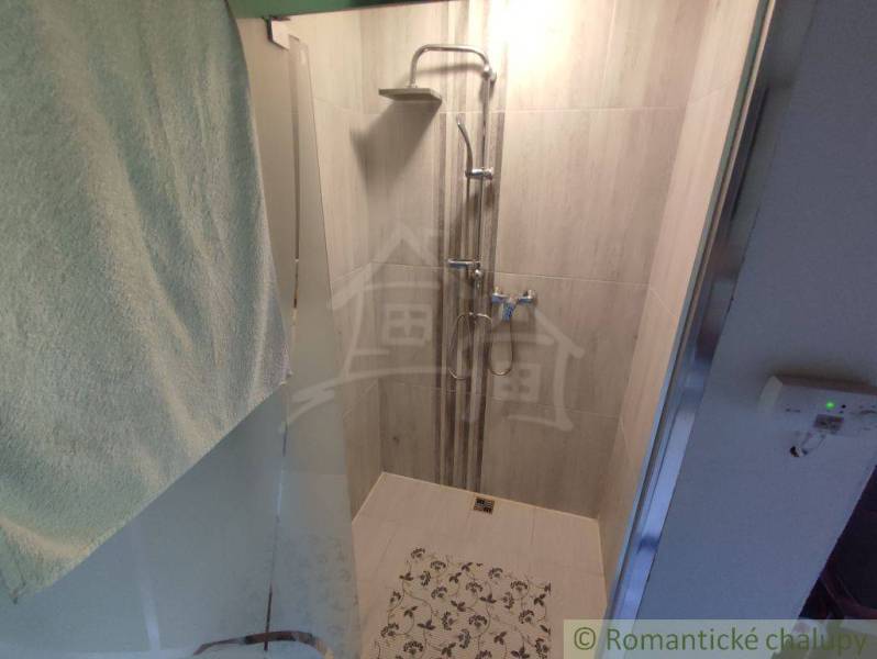 Shower corner with tiles and a towel in a family house.