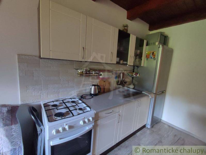 A kitchen in a family house with white cabinets and a gas stove.