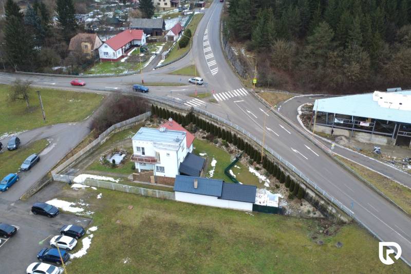 A family house on SNP Street in Považská Bystrica, surrounded by greenery and road infrastructure.